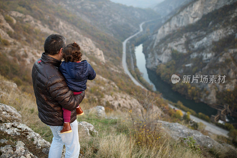 父亲和女儿在山上欣赏风景