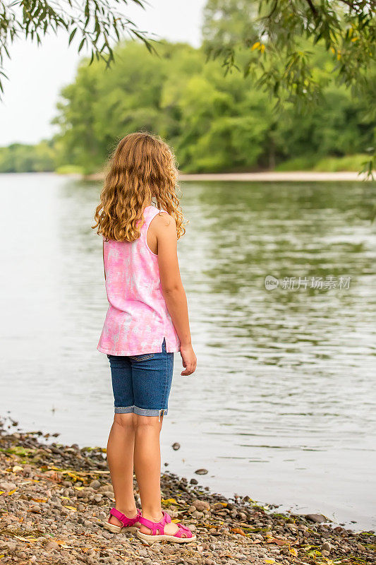 站在密西西比河岸边的年轻女孩