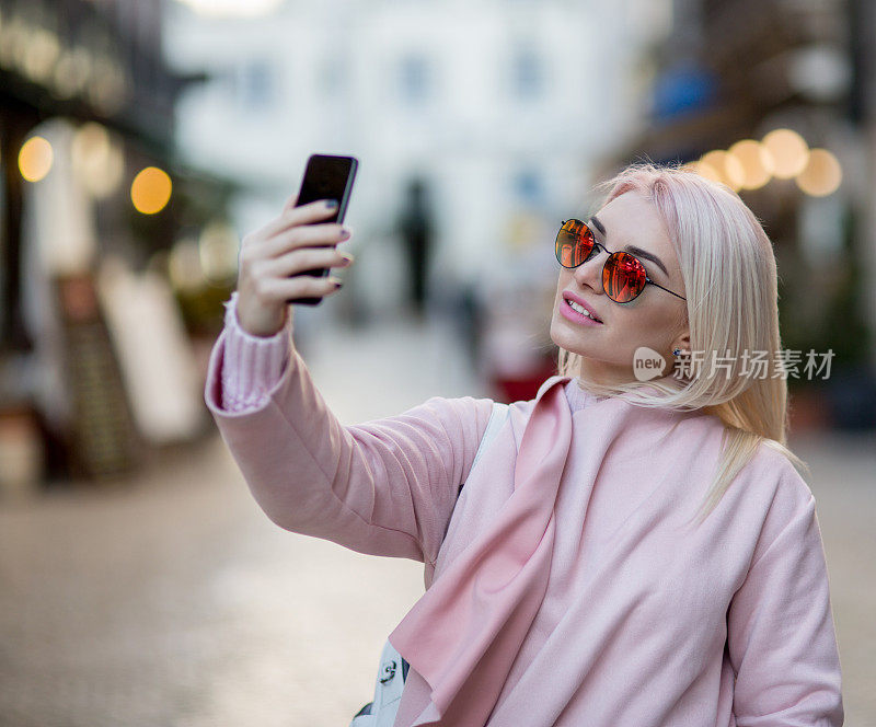 现实生活中的时尚年轻女子，她在自拍