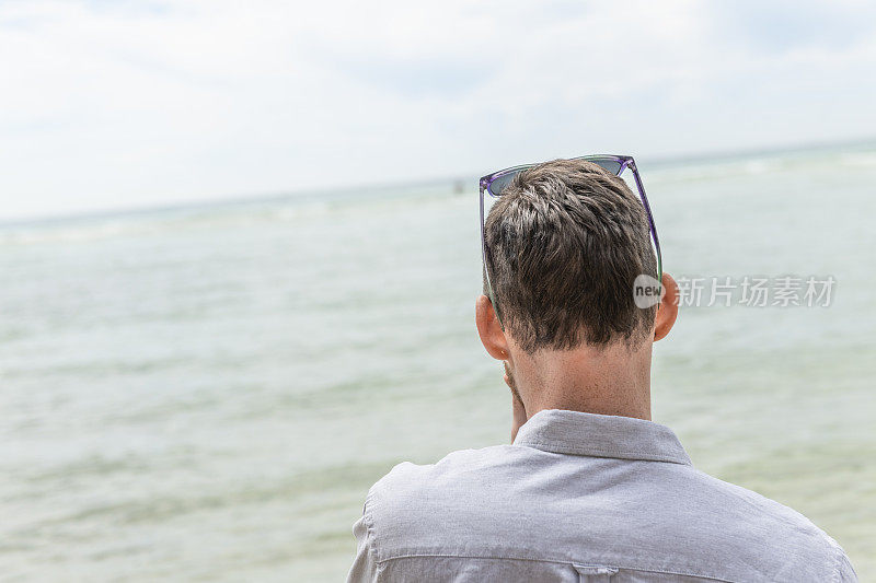 康沃尔，一名男子望着佩顿·范德海滩的水面