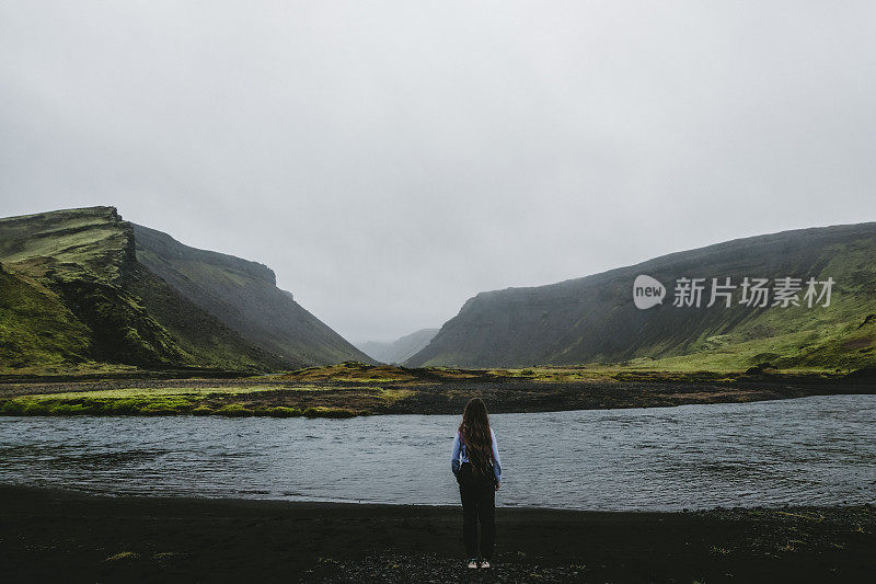 女人呆在冰岛高地美丽的湖和山附近