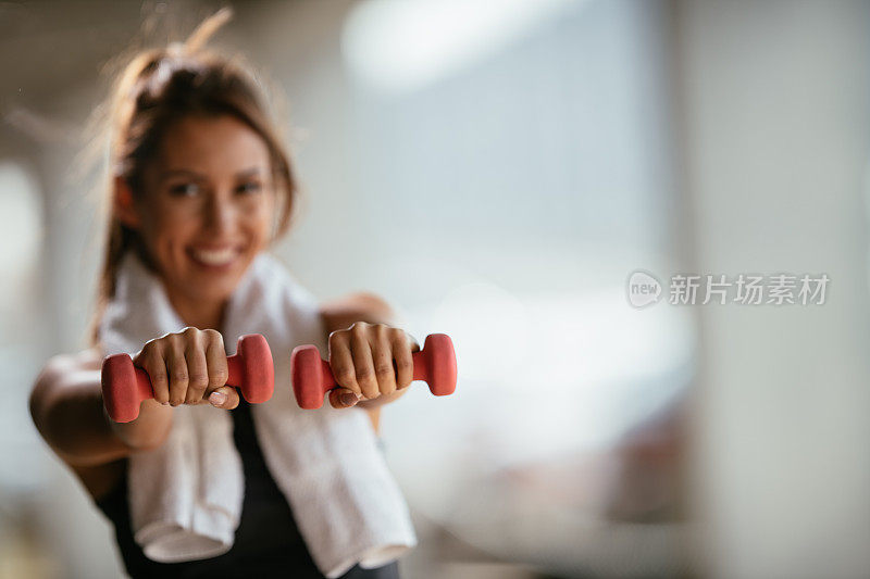 年轻的健身女性用哑铃锻炼