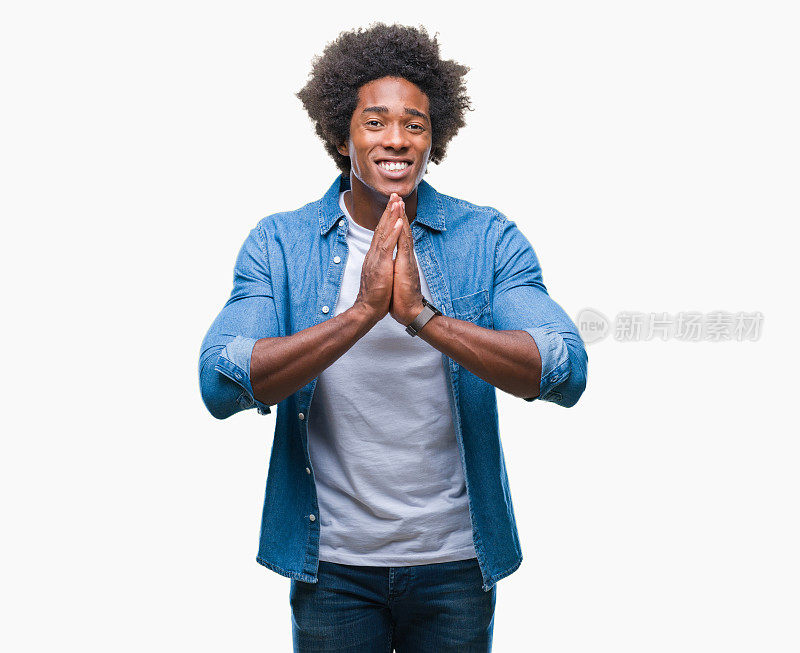 一名来自偏远地区的美国黑人男子双手祈祷，自信地微笑着请求宽恕。