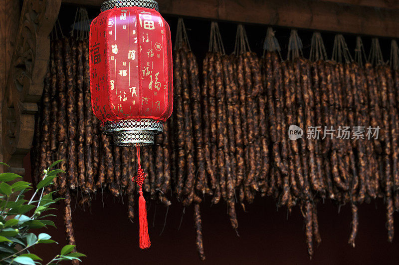 一个中国市场的摊位上挂着腊肉和红灯笼