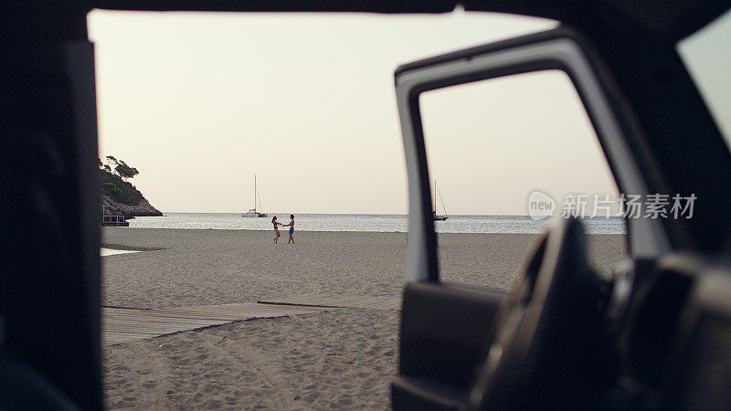 一对夫妇逃往海滩。从SUV车窗看出去