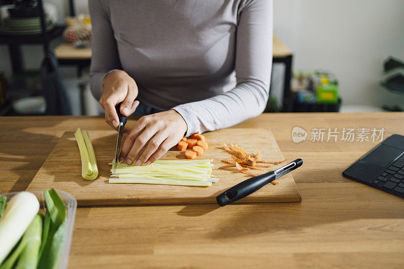 近妇女的手切割韭菜砧板