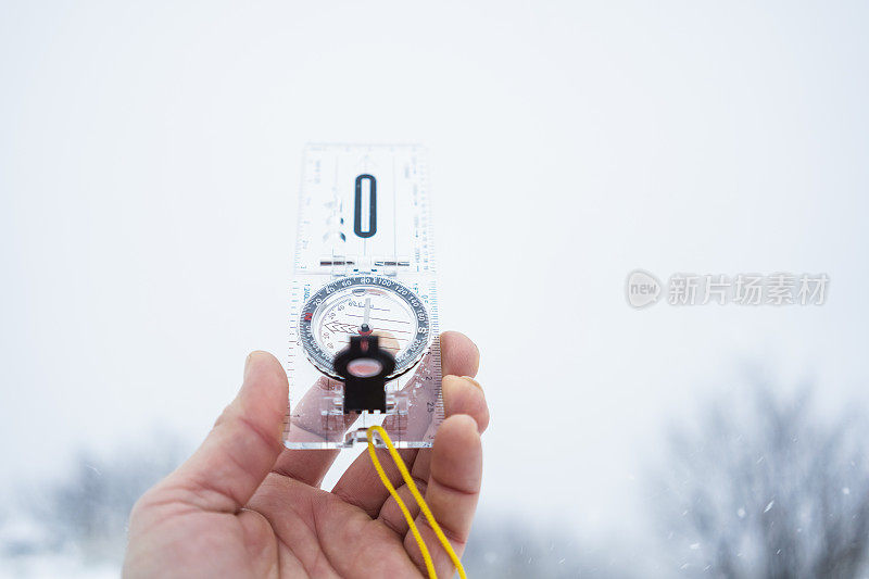 人的手与指南针，雪和雾背景