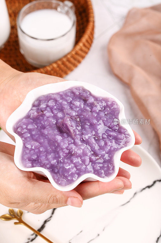 手里端着一碗紫薯米粥