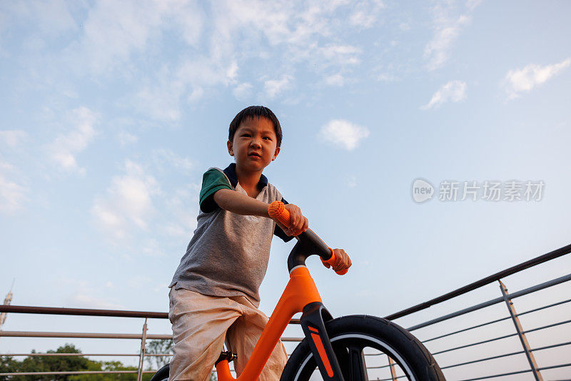 这个小男孩正在学骑自行车