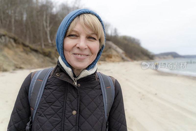 微笑的50岁成熟的女人休息在波罗的海的海滩。