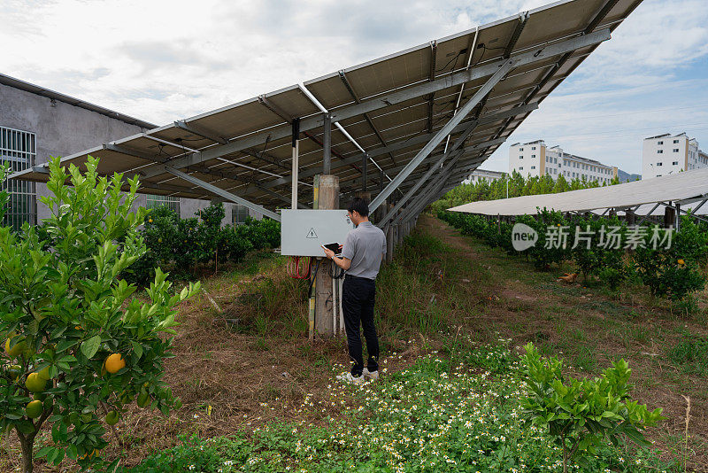 男工程师正在检查太阳能电池板的光伏合流箱