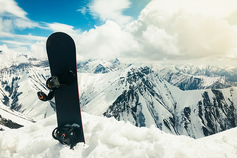黑色滑雪板在雪上与白色的山为背景。滑雪季节结束的概念。Sakartvelo。格鲁吉亚寒假全景