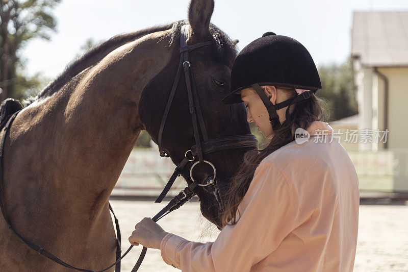 一名女子在赛马场上拥抱一匹马