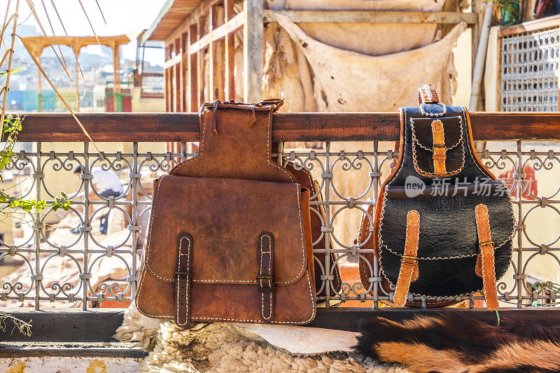 在非洲摩洛哥菲斯，两个皮革背包暴露在一个制革厂的露台上出售