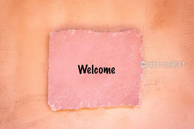粉红色石板招牌上写着欢迎
