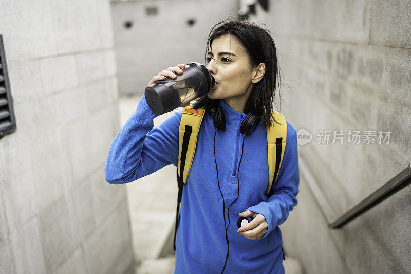 年轻女子在户外运动后喝水