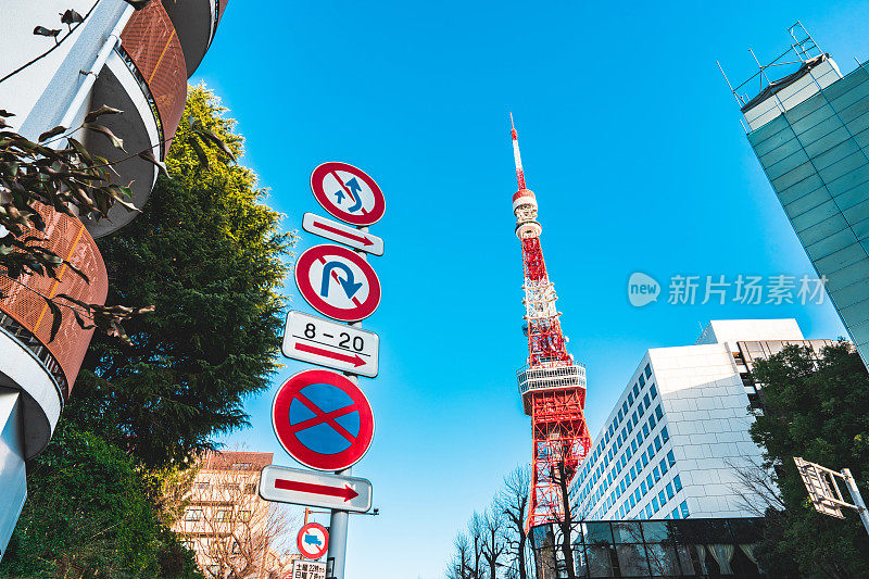 以东京塔和落叶树枝为背景的日本路标