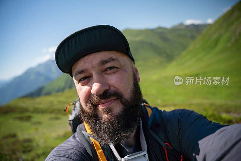 在高山上自拍。成熟的大胡子徒步旅行者在高山上自拍