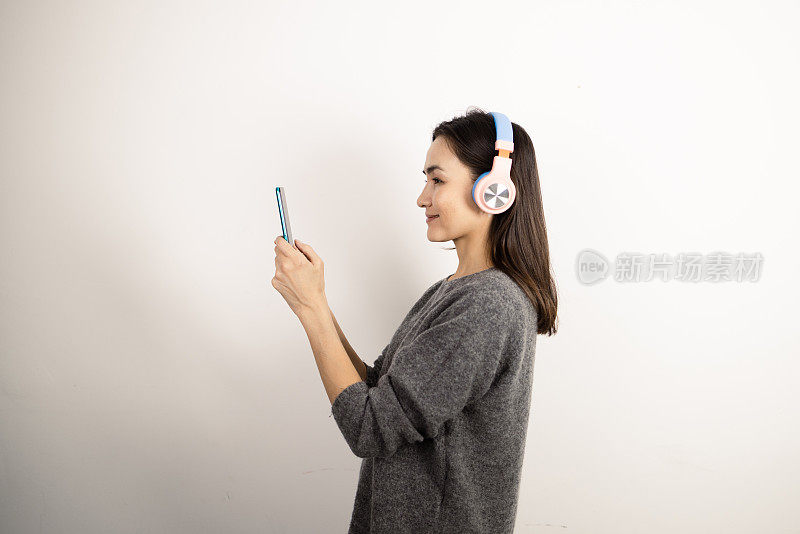 快乐的女人用手机应用程序听音乐