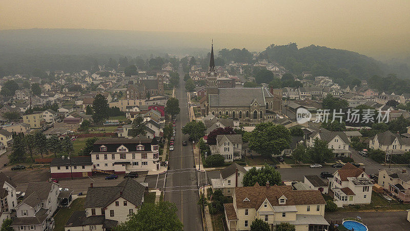 野火烟雾笼罩下的富裕社区。阿巴拉契亚山脉沐浴在夕阳在波科诺斯，宾夕法尼亚州。鸟瞰图