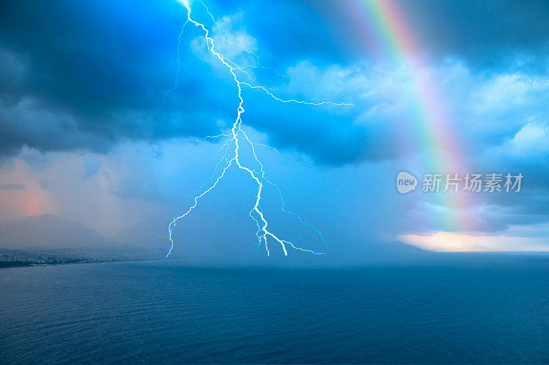 风雨交加的天气电闪雷鸣，乌云之间，彩虹在背后