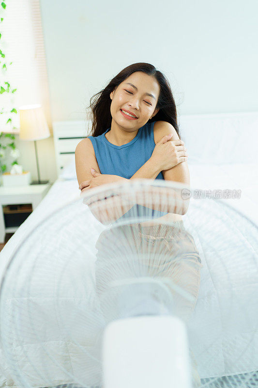 舒适的女人使用电风扇。