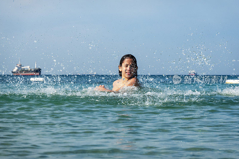 他用手在海里泼水。一个夏天的早晨。忒涅多斯岛。爱琴海北部，12岁的帅哥。长头发的