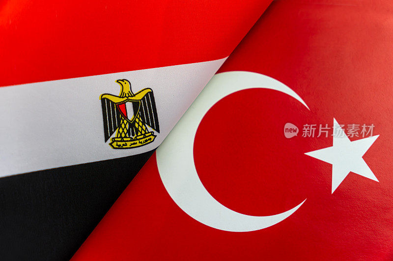 背景是埃及、土耳其的国旗。两国之间相互作用或对抗的概念。国际关系。政治谈判。体育的竞争。