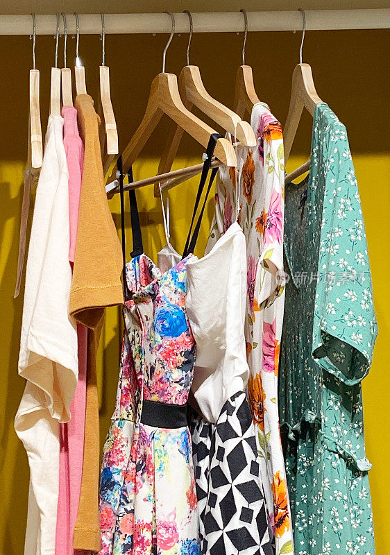 女人的衣橱里有夏天的衣服，衣架上有五颜六色的衣服。创意概念的服装陈列室，设计师服装店。