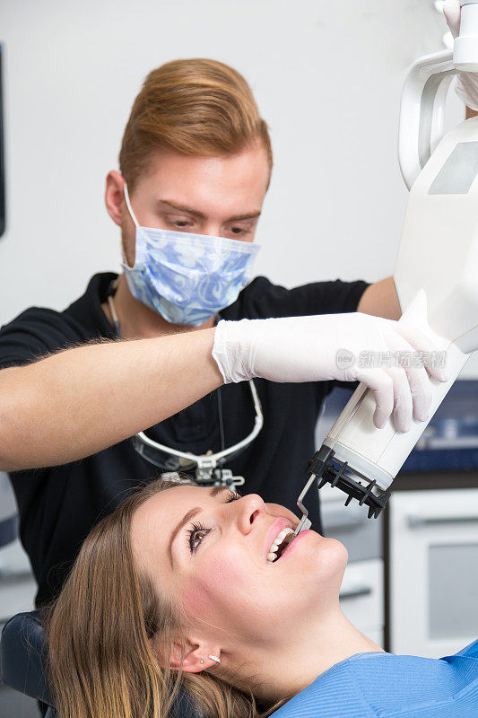 牙医或放射科医生用x光设备扫描病人的牙齿