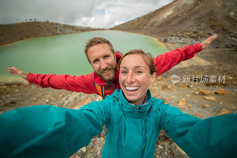 一对年轻夫妇在汤加里罗阿尔卑斯山徒步旅行，拍自拍照