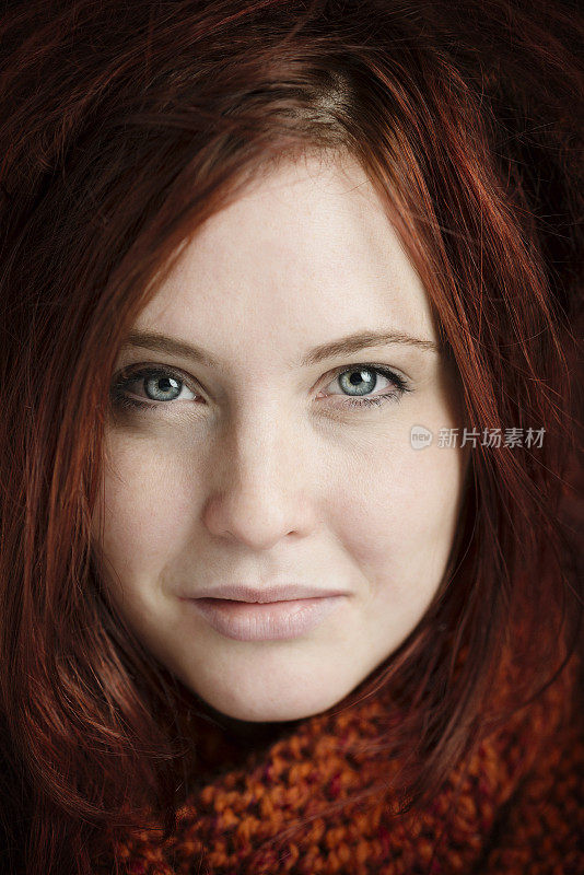 一个微笑的红头发年轻女人的肖像
