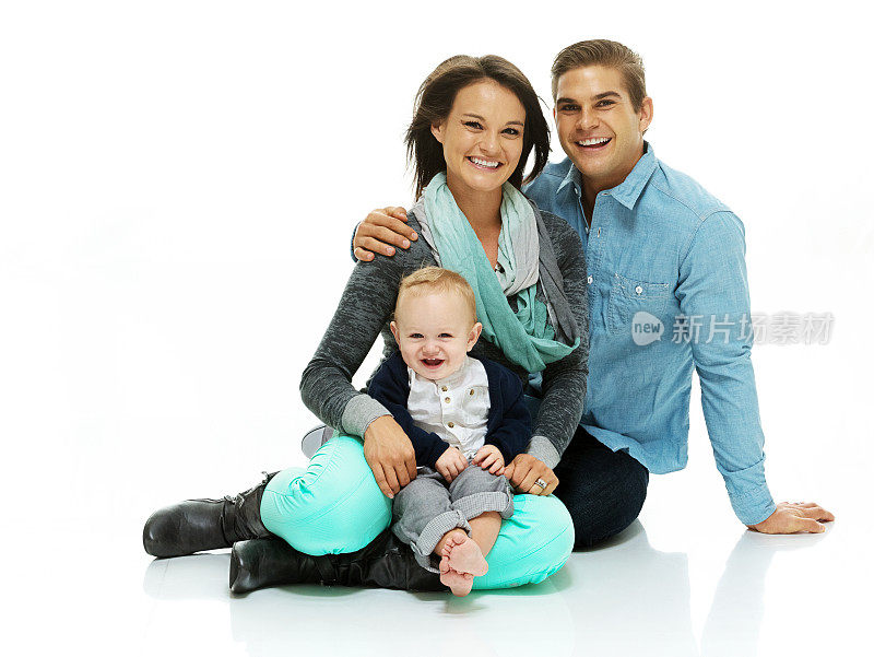 一对幸福的夫妇和他们的孩子坐在地板上