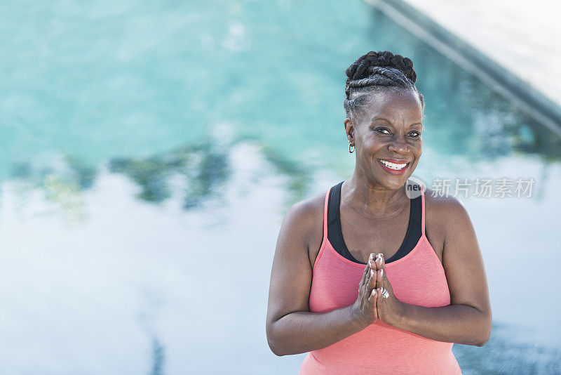 一个成熟的非裔美国女人站在游泳池旁