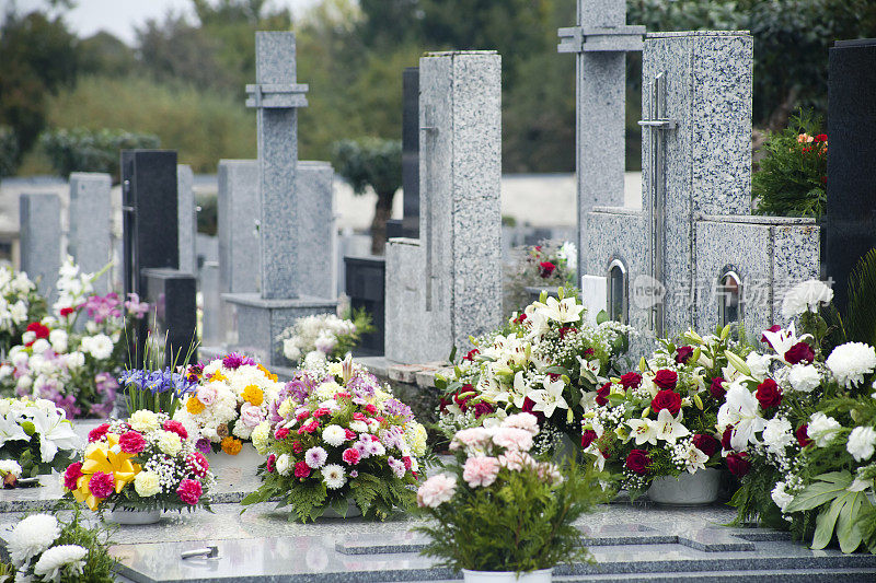 十字架，花束，墓地里的墓碑。