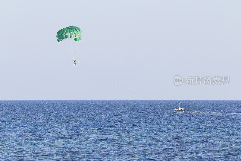 在塞浦路斯的阿伊纳帕，绿色的伞枝和蓝色的地中海