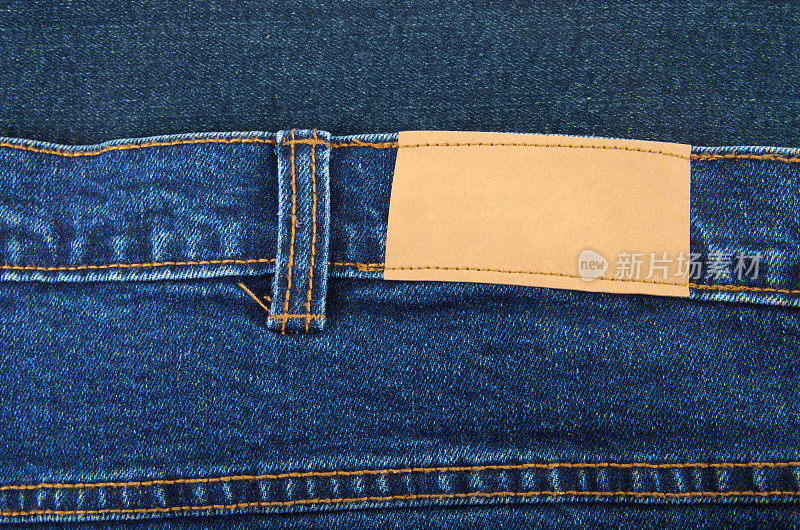 蓝色牛仔牛仔裤的腰带环和标签细节
