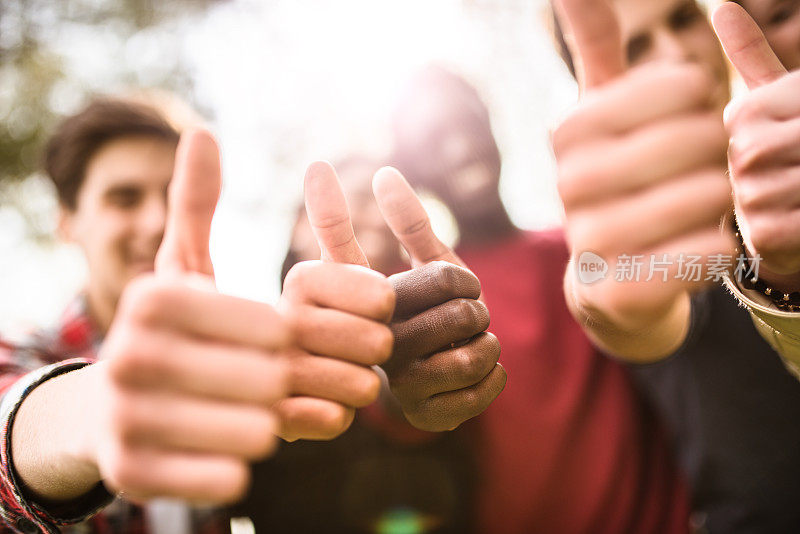 多种族的大学生在黄昏时竖起大拇指