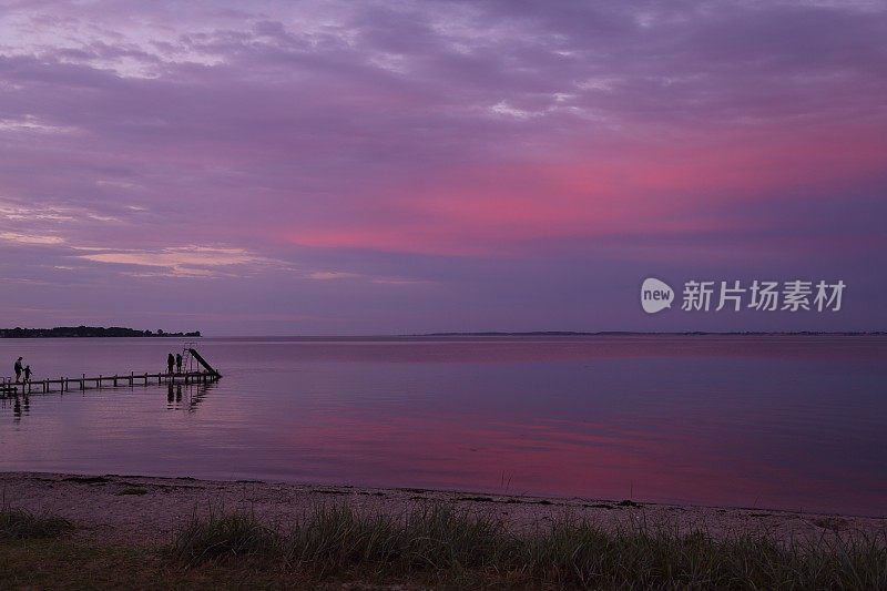 日落后，在海滩粉红色的天空