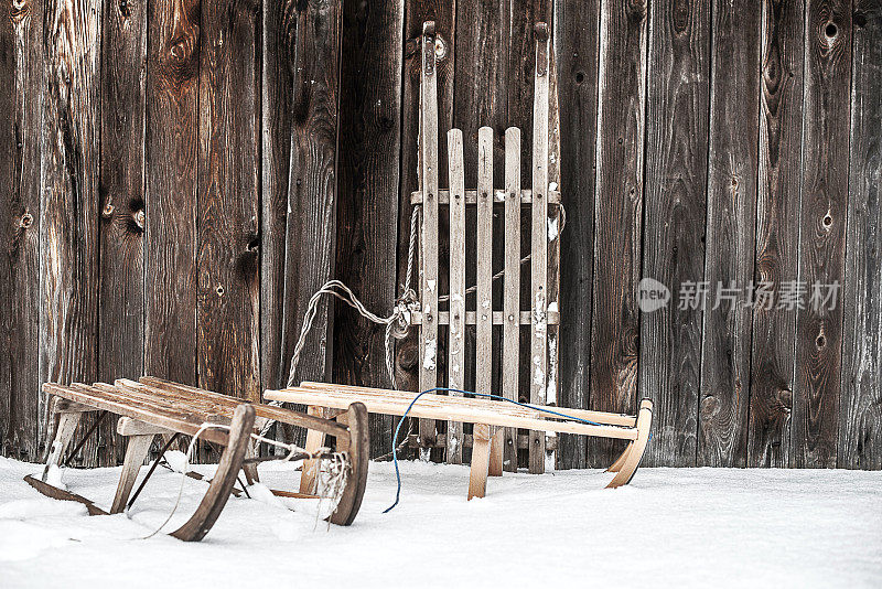 三架旧雪橇挂在木墙上