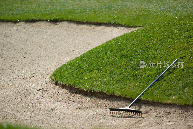 高尔夫球杆的沙坑，有耙子和沙子