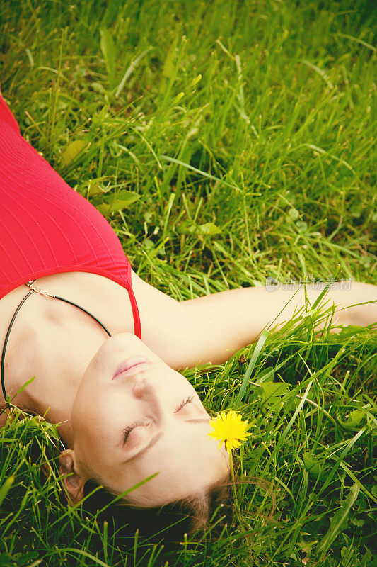 美丽的女人躺在草地上
