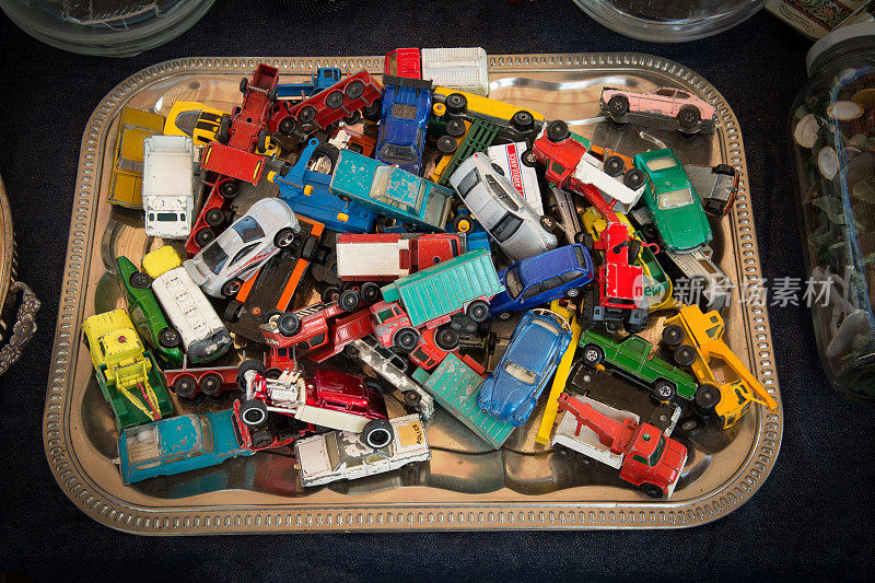 一堆玩具车放在银托盘上