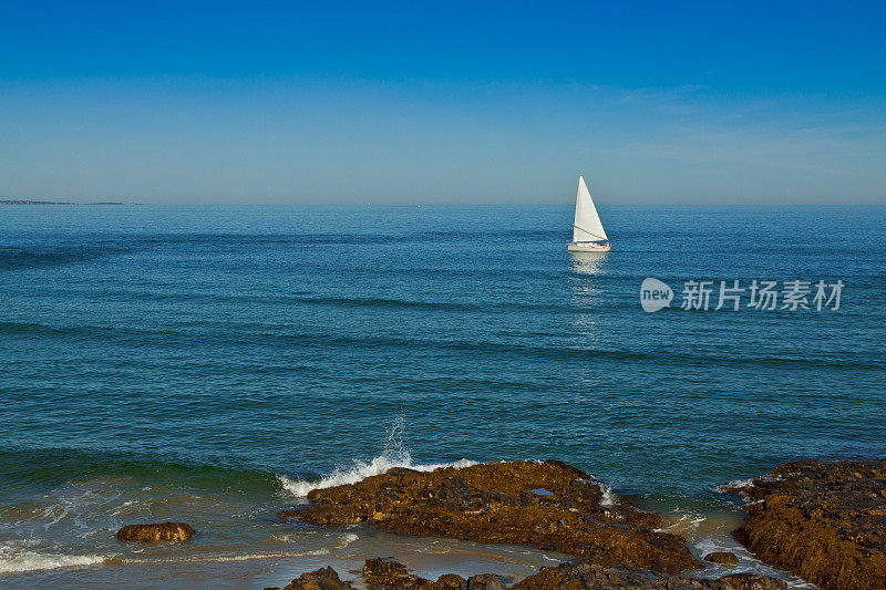 岩石和海浪。缅因州的背景是一艘帆船。