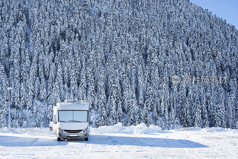 在白雪覆盖的森林中行驶的休闲车辆