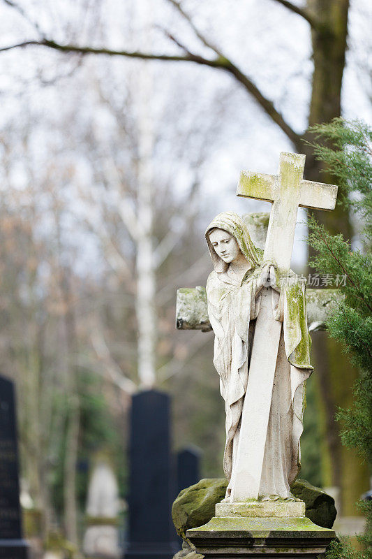 圣母玛利亚的雕像和十字架在墓地。