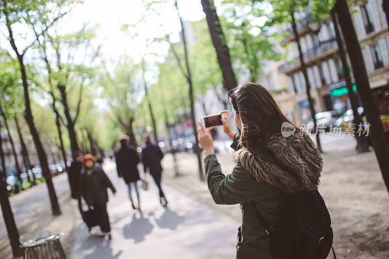 一名年轻女子在巴黎街头拍照