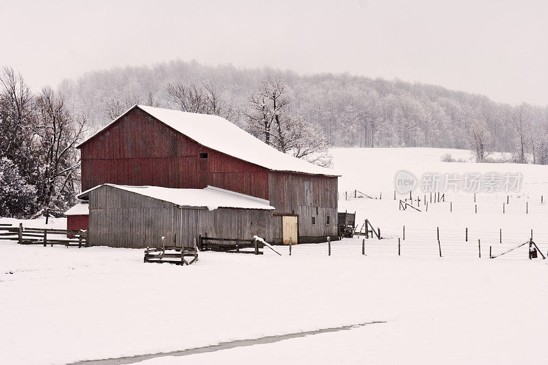 红色谷仓在春天的暴风雪