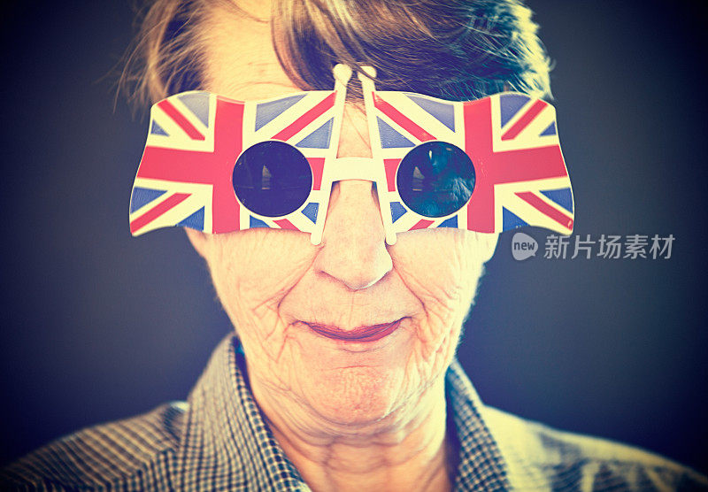 戴着英国国旗太阳镜的资深女士傻笑着
