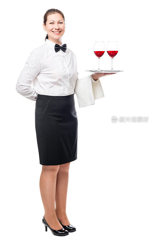 深色头发的女人作为一个服务员，拿着一盘葡萄酒在一个工作室隔离